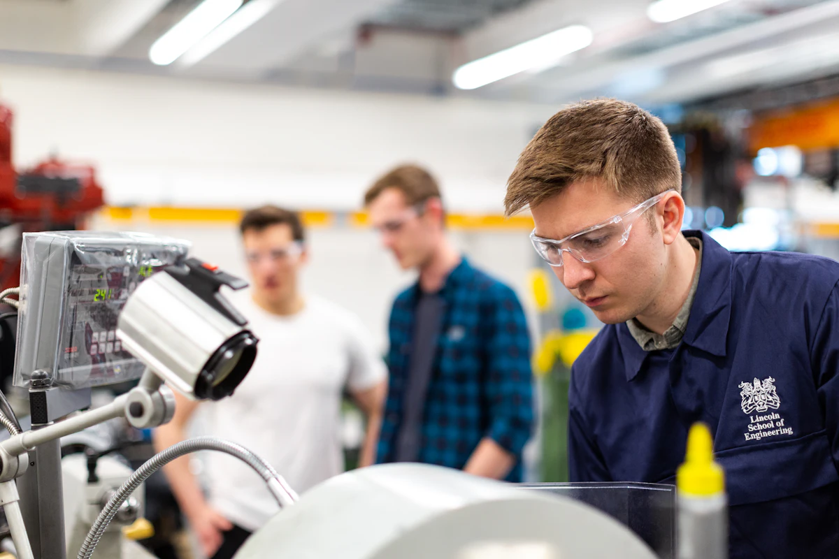 Engineer in safety glasses operating machinery in an engineering workshop
