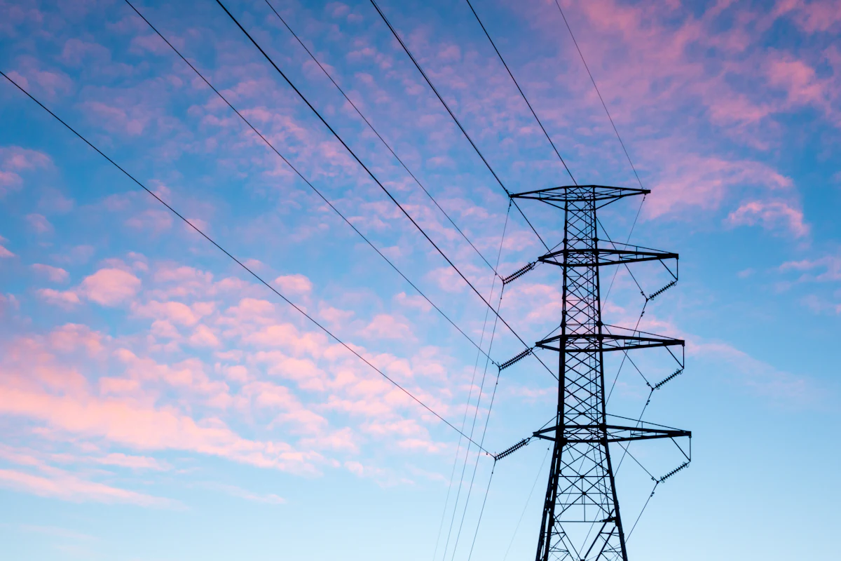 Electric pylon and power lines against an orange evening sky